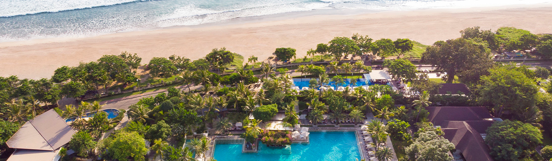 Drone view of Padma Resort Legian next to Legian Beach in Bali, Indonesia