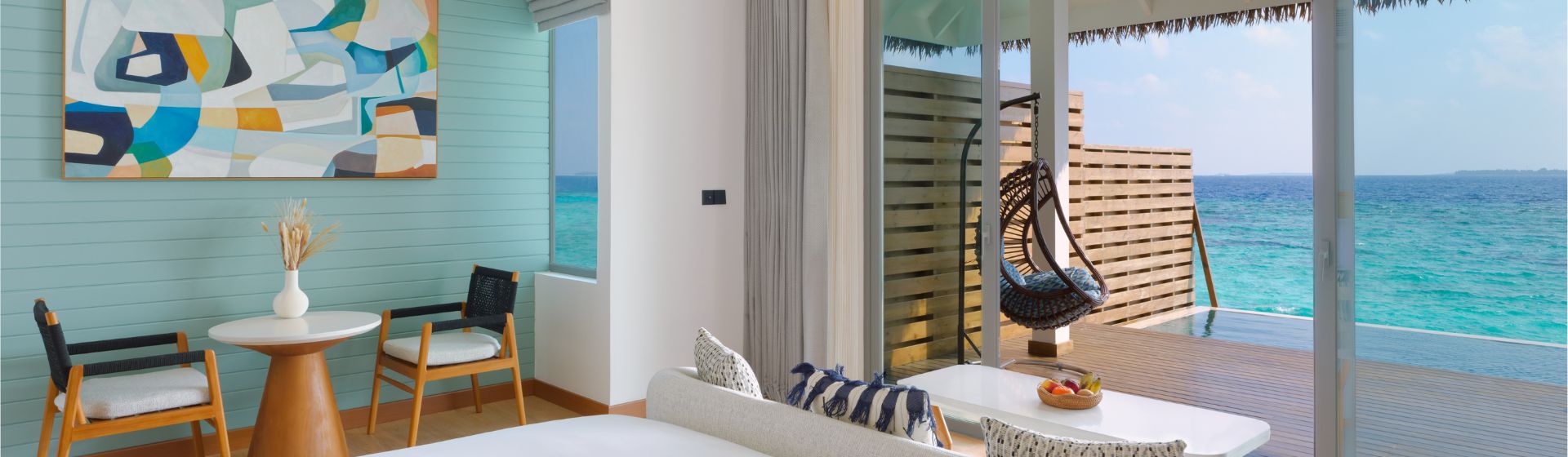 View from the bedroom of an overwater pool villa at DusitD2 Feydhoo Maldives, looking out into the blue ocean