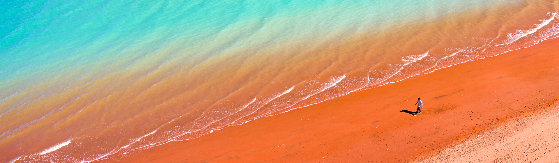 Aerial view of a person walking along the beach at roebuck bay, western australia
