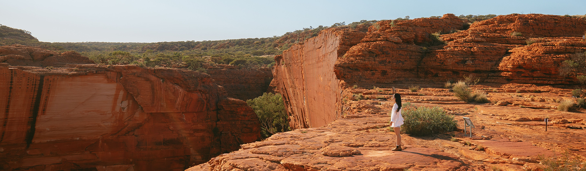 A woman standing on a cliff top at Kings Canyon, Northern Territory, Australia