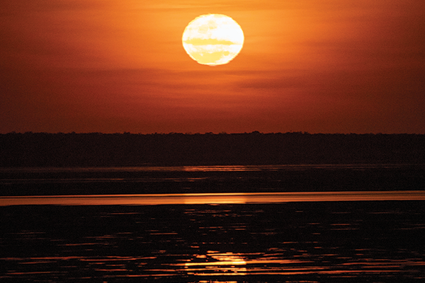 Moonrise on the exposed mudflats during low tide at Roebuck Bay in Broome, Western Australia
